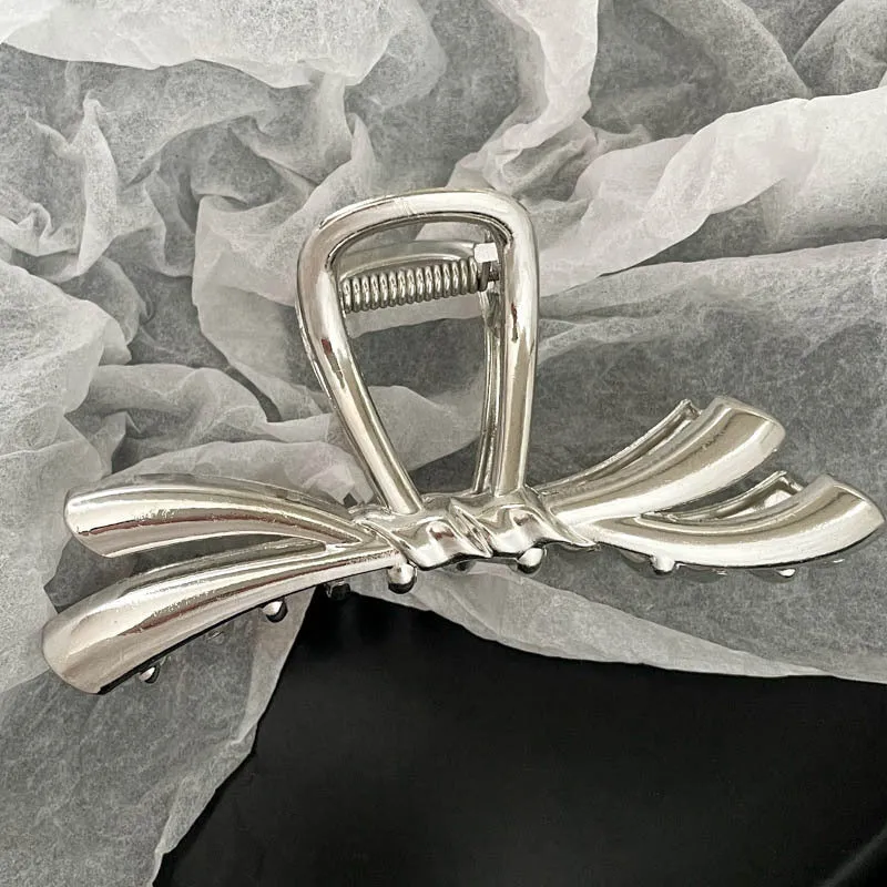 Assortment of silver metal hair barrettes and claw clips in various Korean-style designs on a white background.