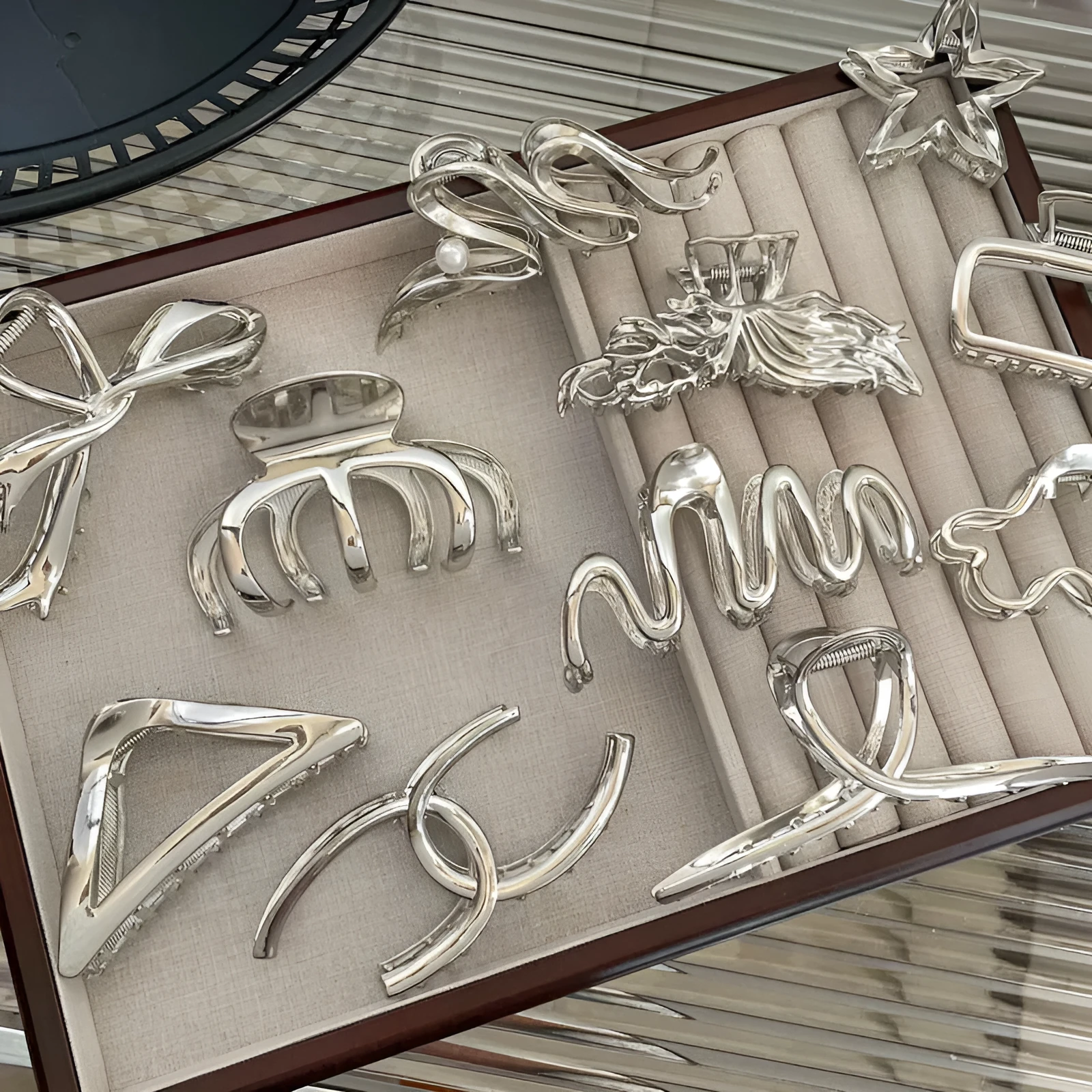 Assortment of silver metal hair barrettes and claw clips in various Korean-style designs on a white background.
