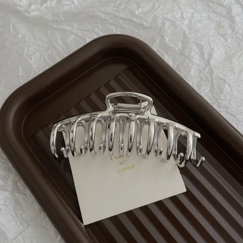 Assortment of silver metal hair barrettes and claw clips in various Korean-style designs on a white background.