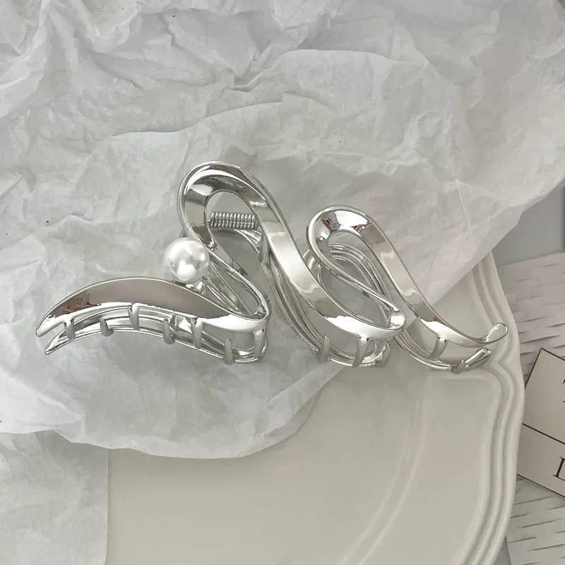 Assortment of silver metal hair barrettes and claw clips in various Korean-style designs on a white background.