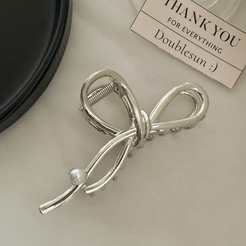 Assortment of silver metal hair barrettes and claw clips in various Korean-style designs on a white background.