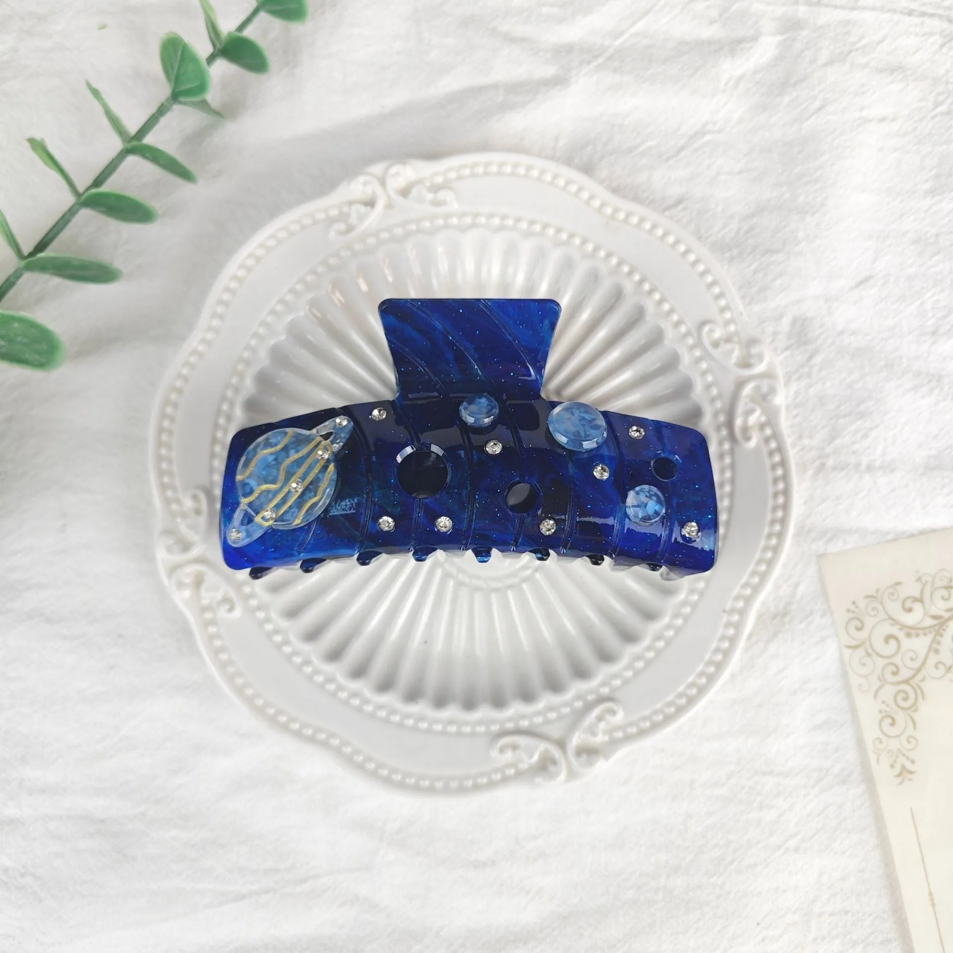Oversized women's barrette with star moon starry sky design in cellulose acetate sheet material