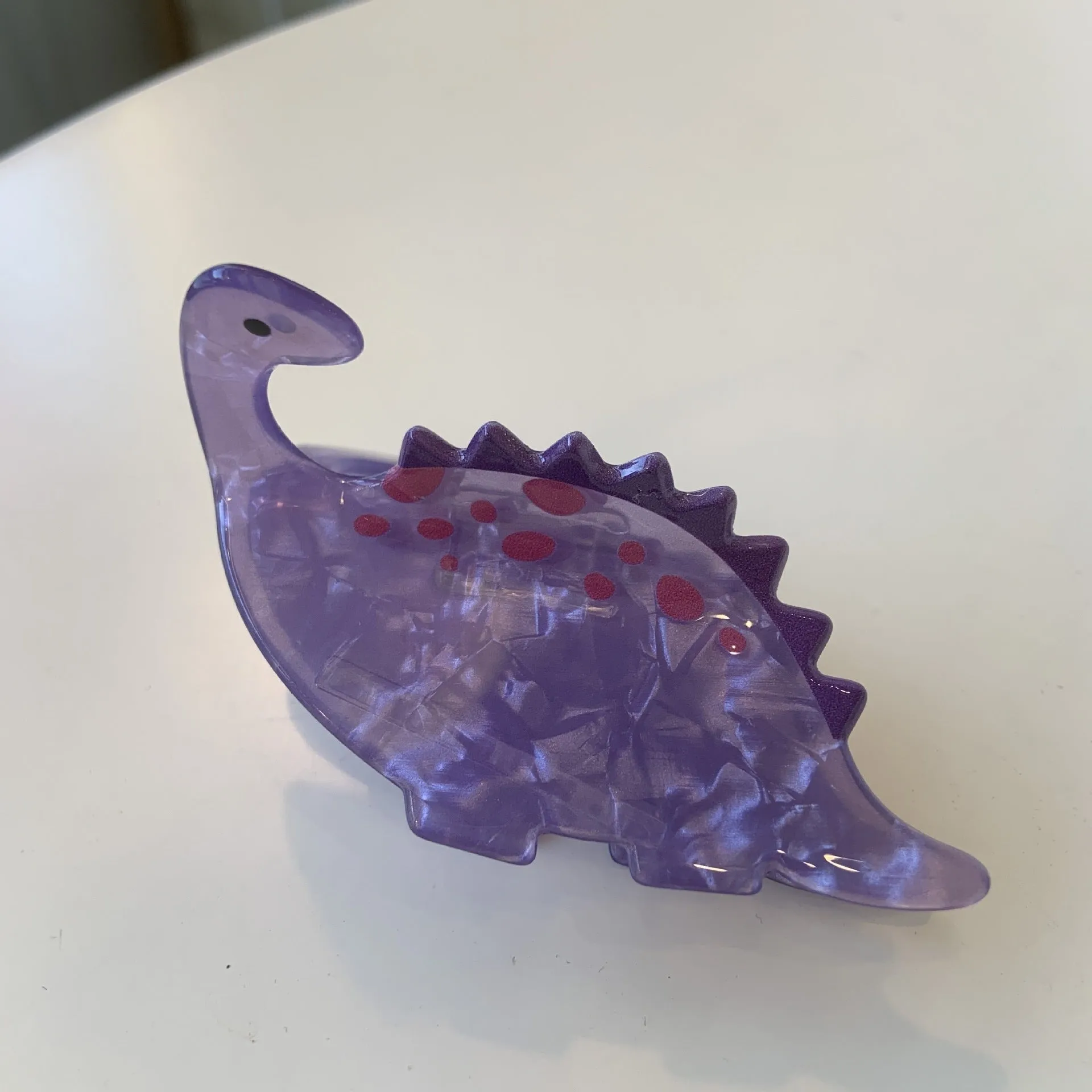 Colourful dinosaur acrylic jaw clip hairpin showing grip design with dinosaur motif