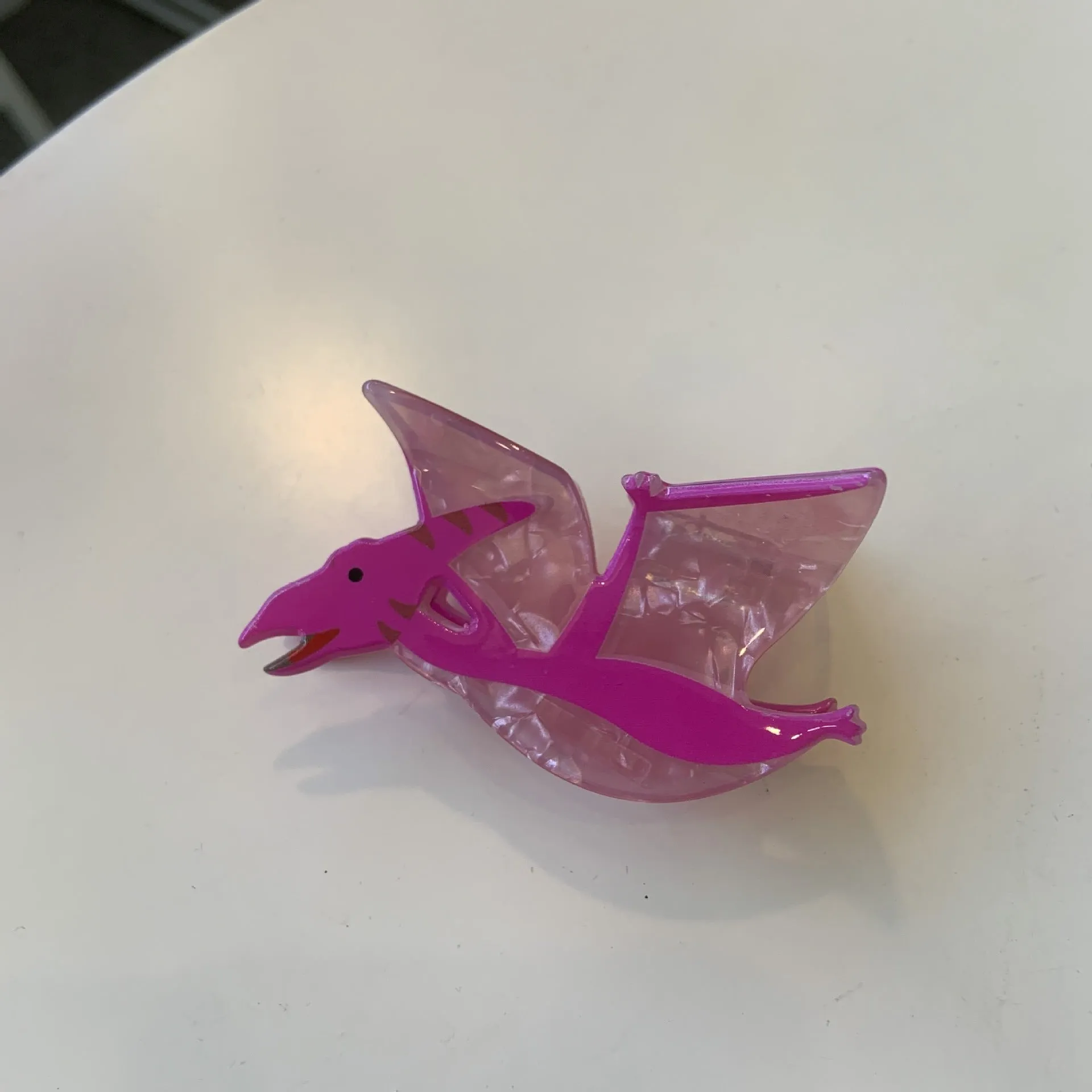 Colourful dinosaur acrylic jaw clip hairpin showing grip design with dinosaur motif