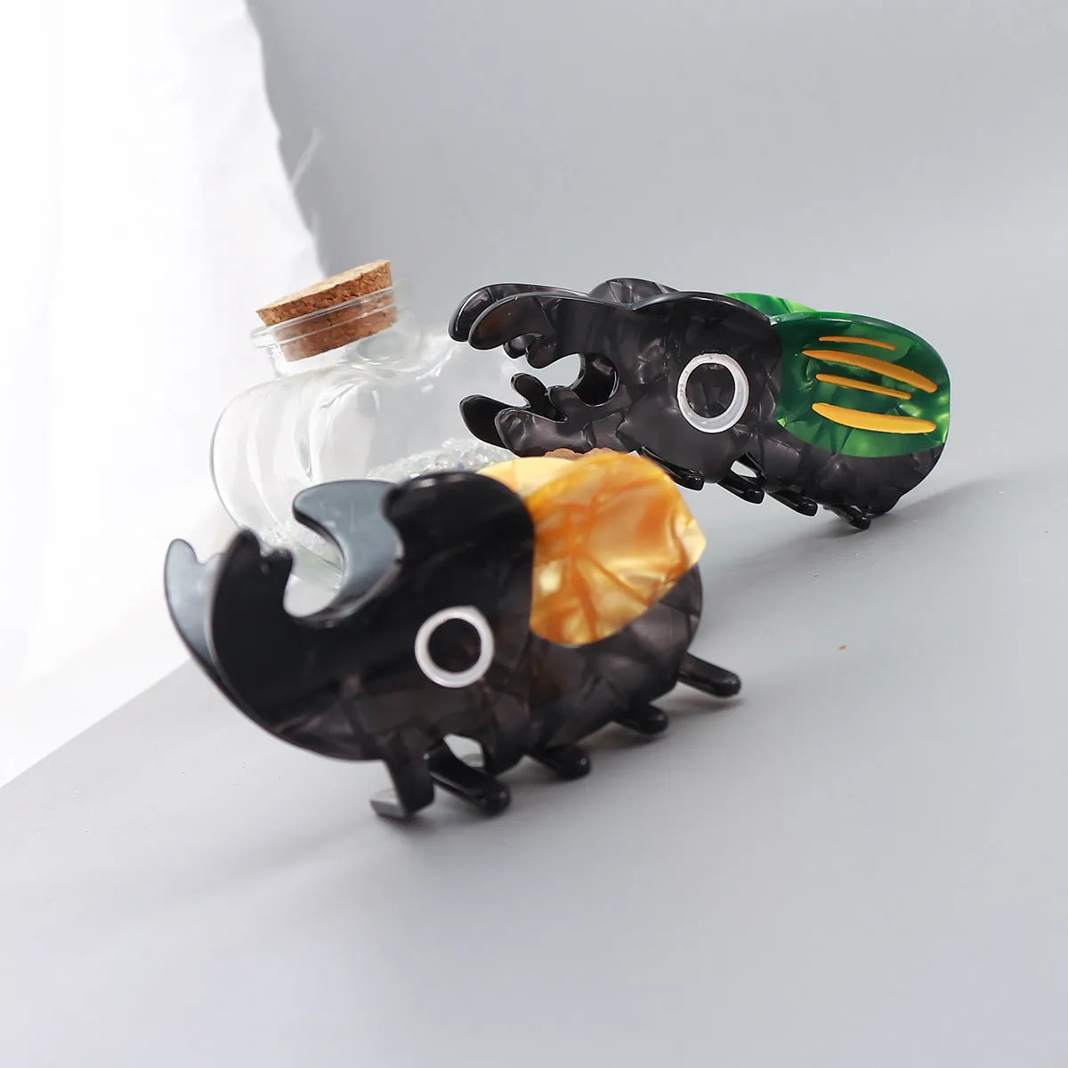 Handmade cellulose acetate beetle grip accessory with cartoon insect biology design in green or orange colour