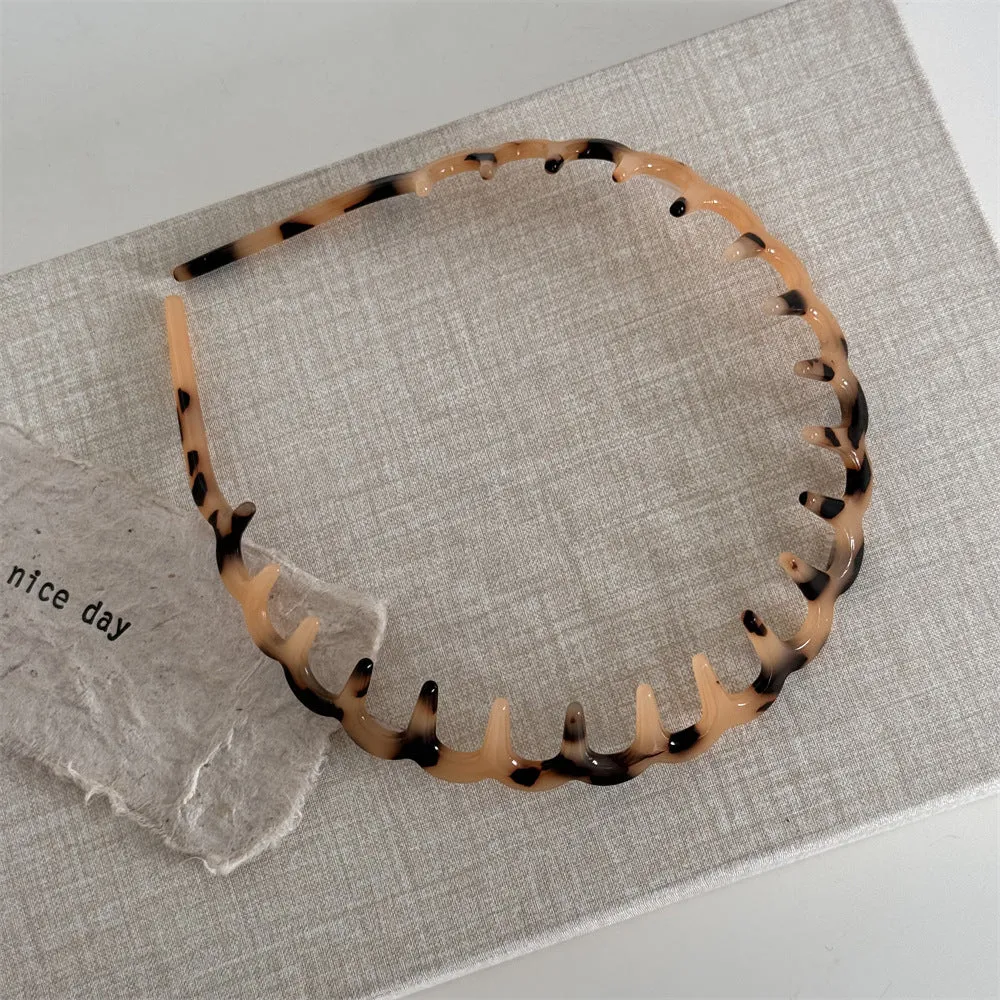 Women's acetate fibre toothed hair hoop in black colour, showing non-slip wave pressure nozzle and irregular Korean-style shape.