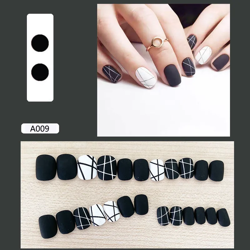 Fake nail patch with matte black and white lines design on a white background