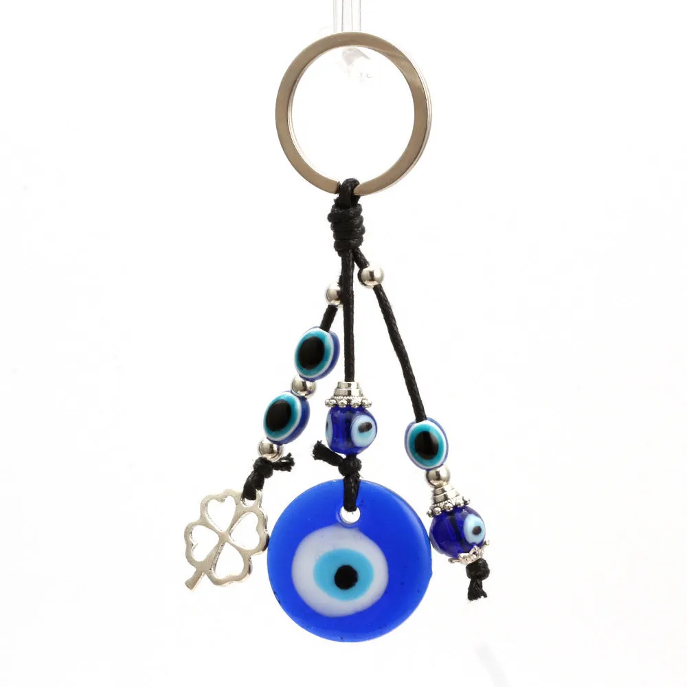 Blue metal eye of evil keychain 4cm pendant with plant-inspired design on grey background