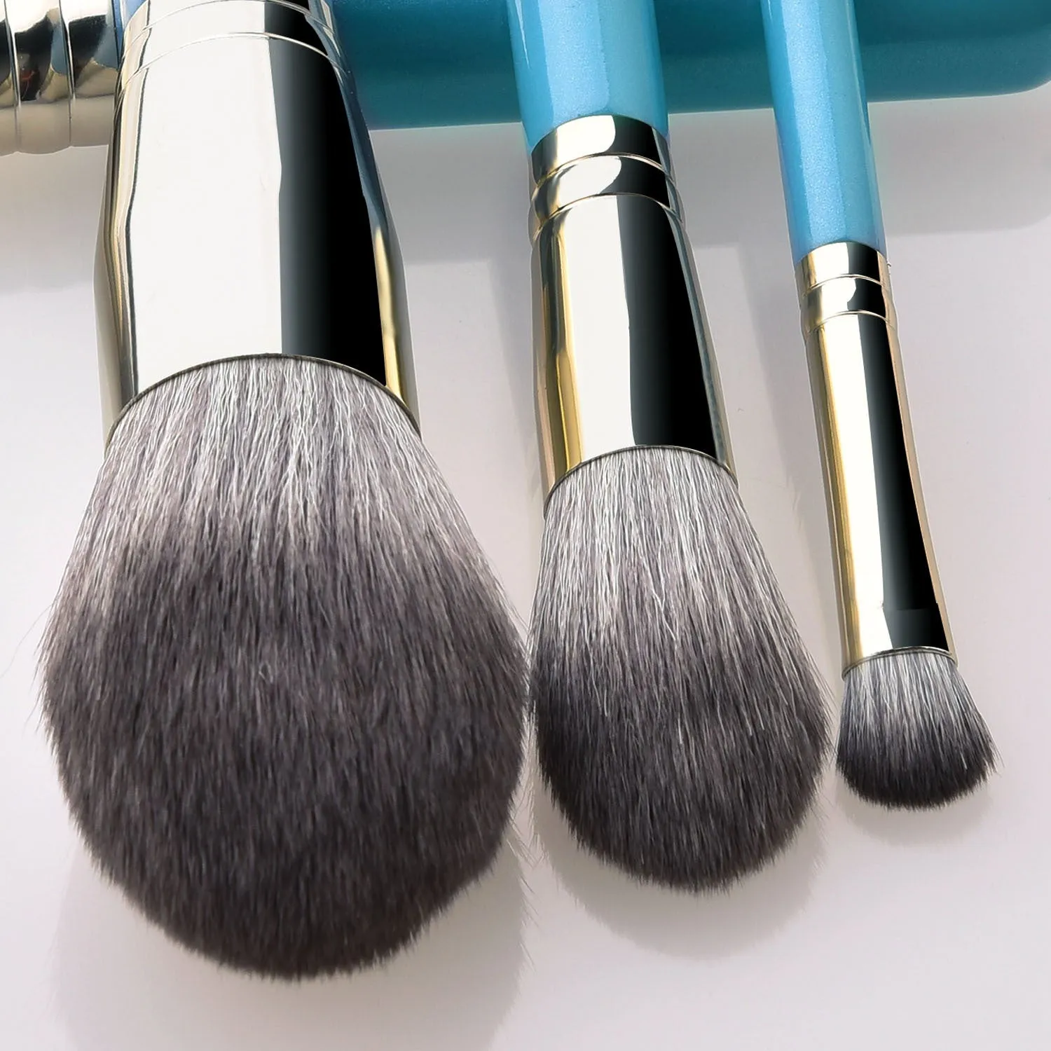 Blue 13-piece synthetic hair makeup brush set with wooden handles and aluminum ferrules on a clean surface