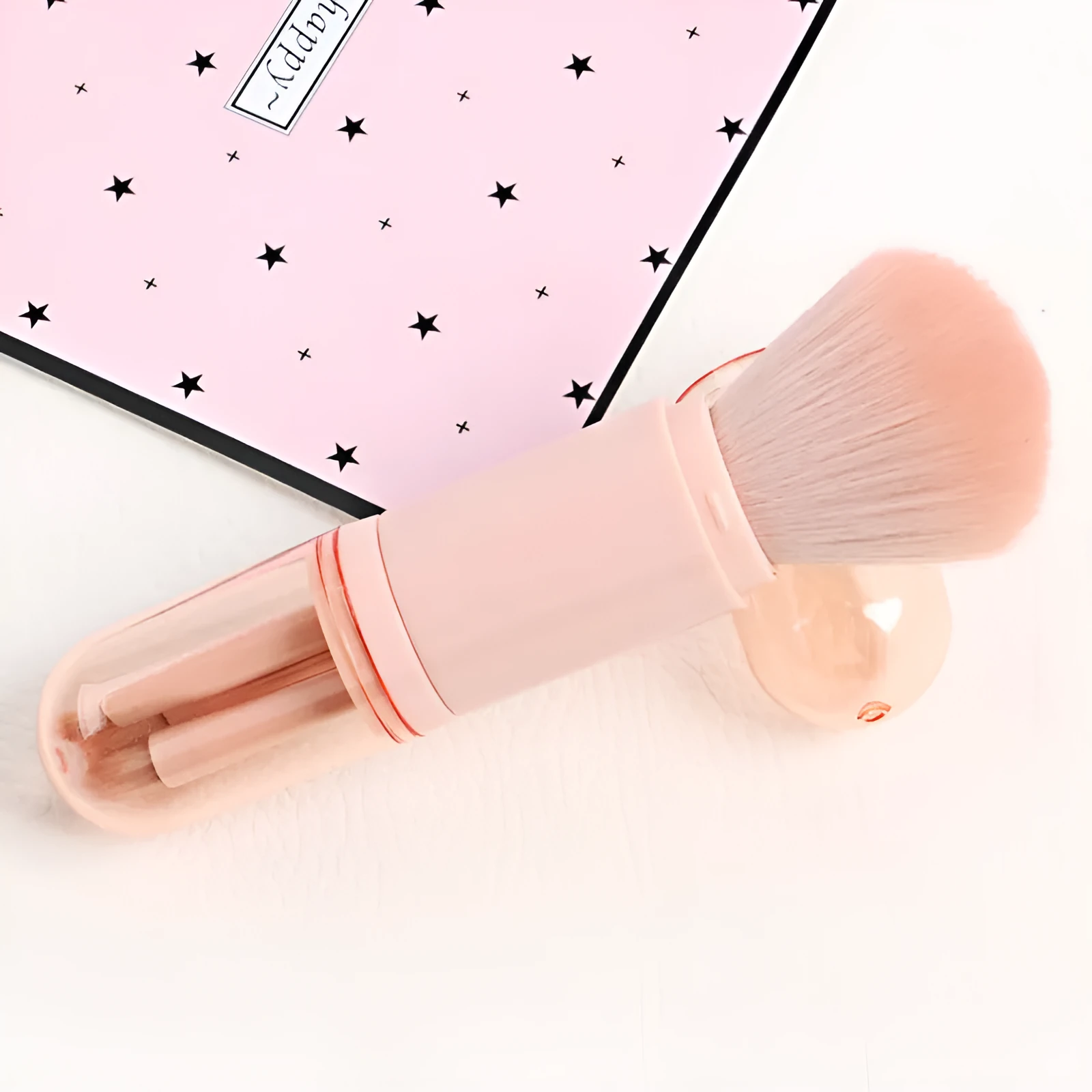Single 4-in-1 retractable makeup brush set with four skin-colour bristle heads, 14cm total length, on a white background