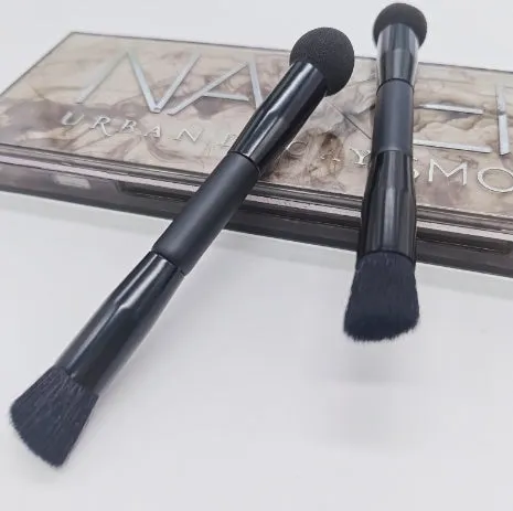 Double-headed concealer brush with black wooden handle, artificial fibre bristles, and angled sponge tip.