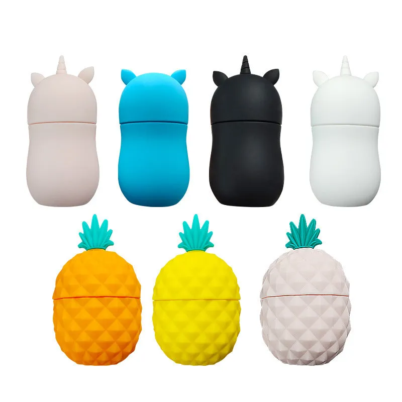 Silicone facial ice mold in pineapple style, pink colour, with ice cubes on a white background