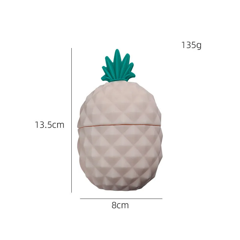 Silicone facial ice mold in pineapple style, pink colour, with ice cubes on a white background