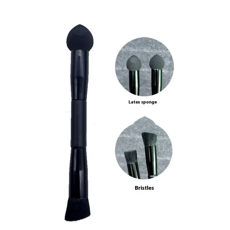 Black wooden handle concealer brush with a grey sponge tip applicator angled for under eye use.