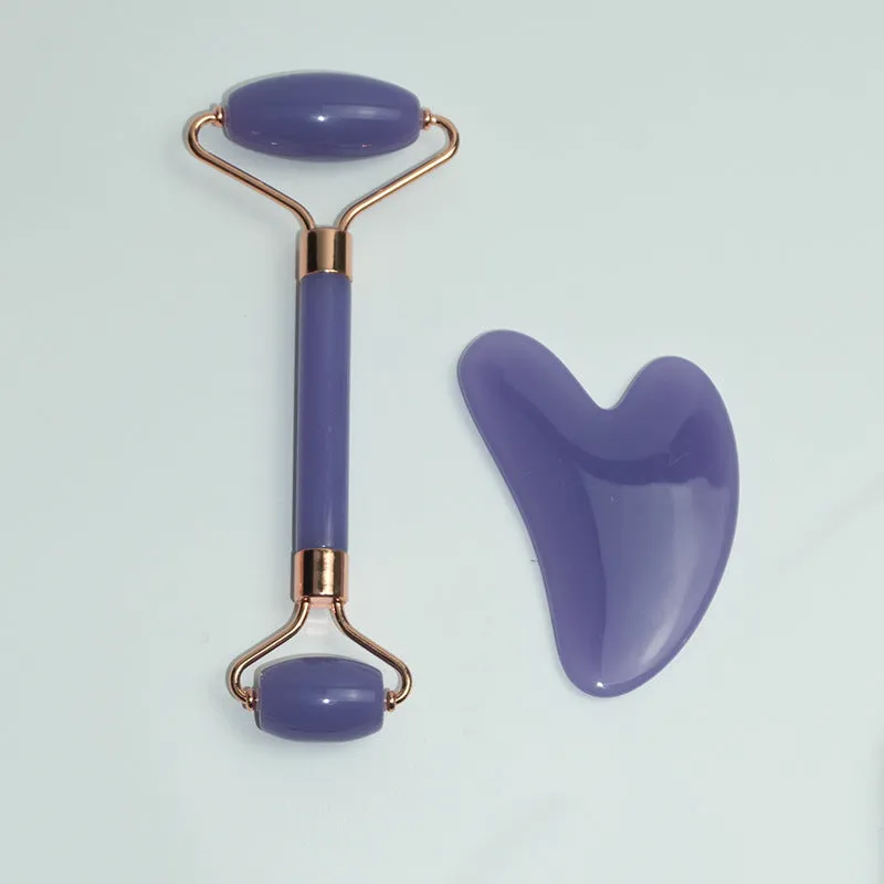 Stainless steel double-headed facial roller, heart-shaped acupressure stick, and scraping plate on a white background.