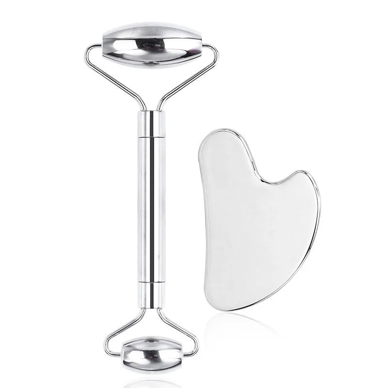 Stainless steel double-headed facial roller, heart-shaped acupressure stick, and scraping plate on a white background.
