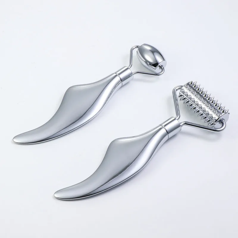 Stainless steel double-headed facial roller, heart-shaped acupressure stick, and scraping plate on a white background.