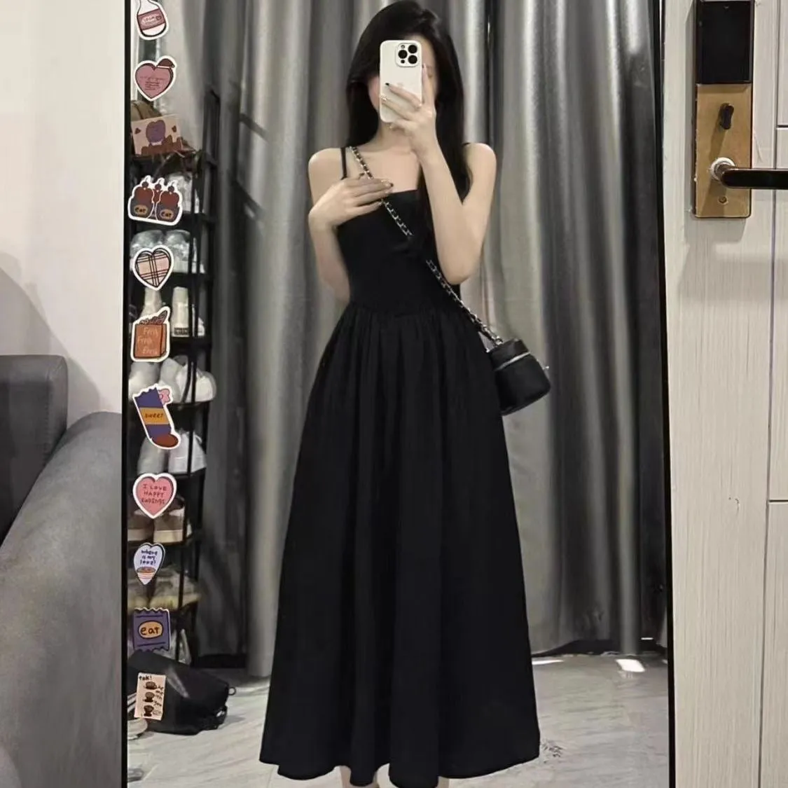 A-line slip dress in black with wide waist and sleeveless design made from polyester