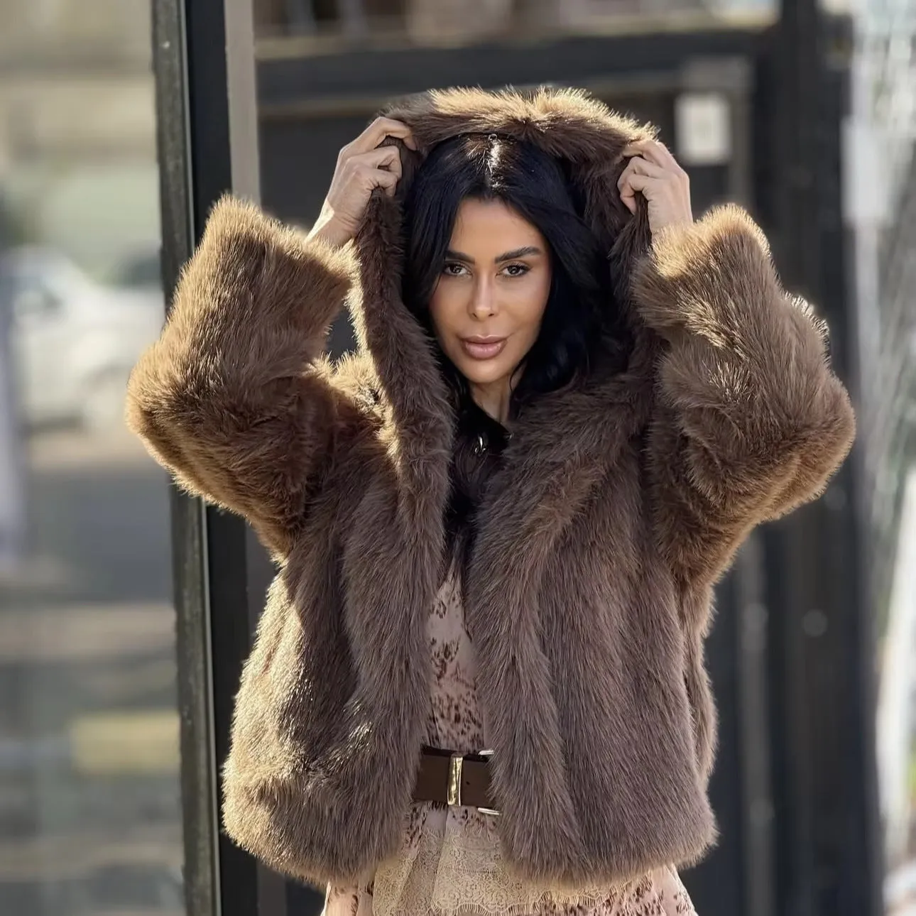 Women's brown loose hooded jacket with fox fur trim on a white background, front view