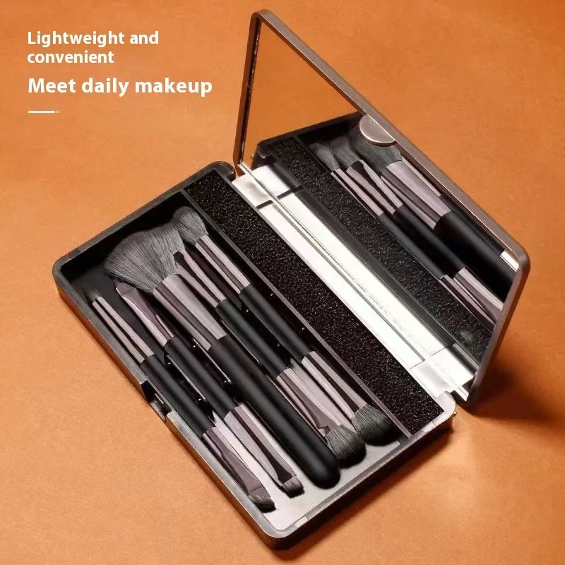 Makeup brush set with mirror showing artificial fibre bristles and plastic handles