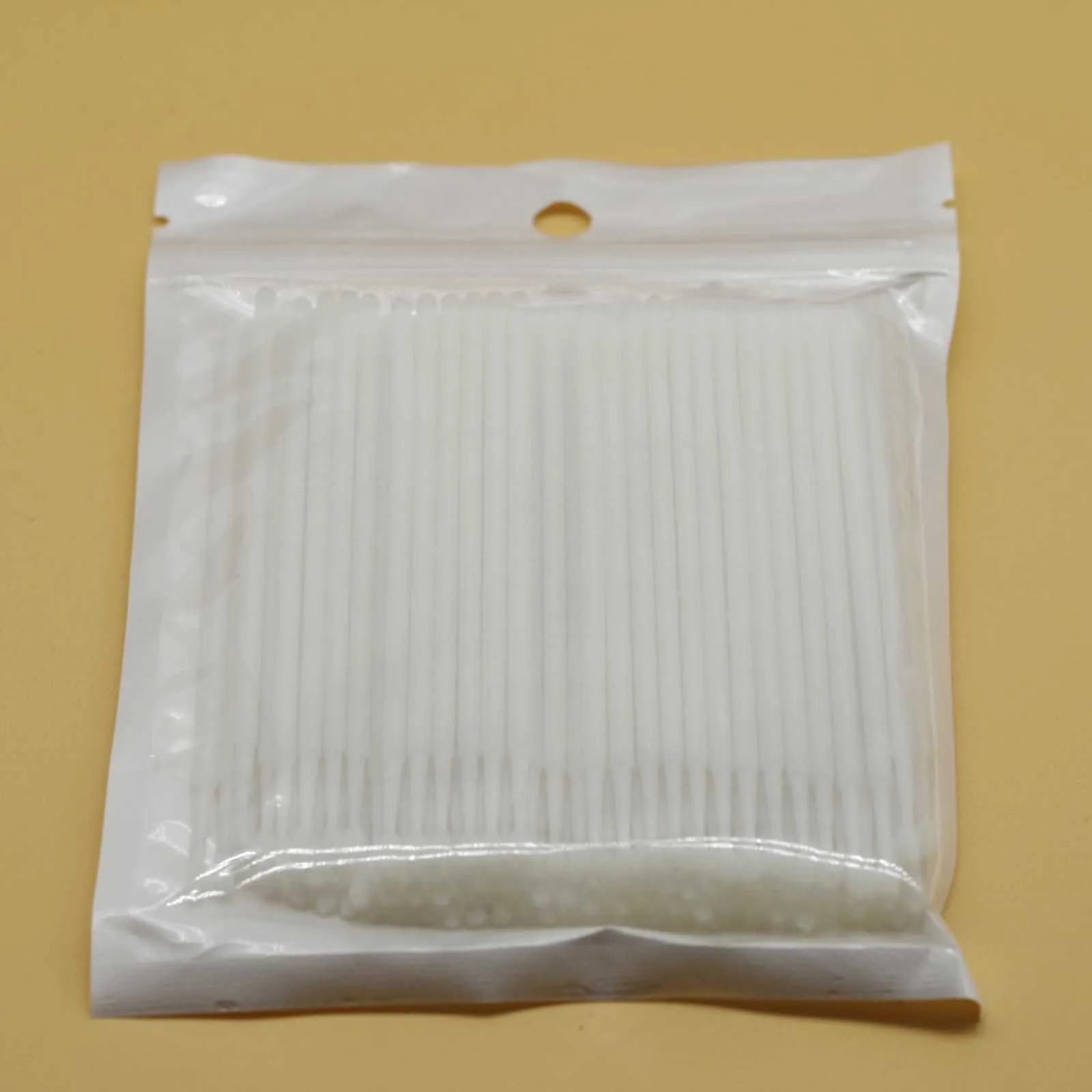 Disposable micro applicator brushes with bendable shafts and flock tips for makeup application