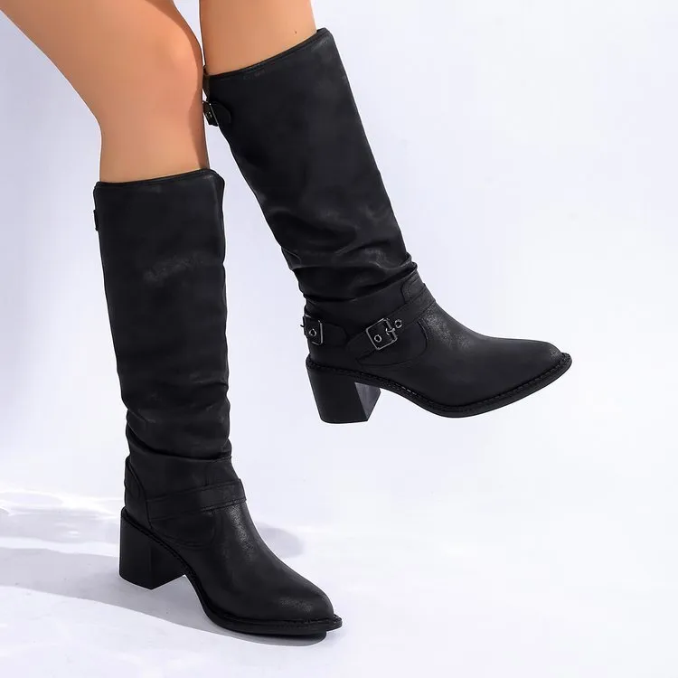 Women's black chunky heel boots with pointed toe and high shaft on display