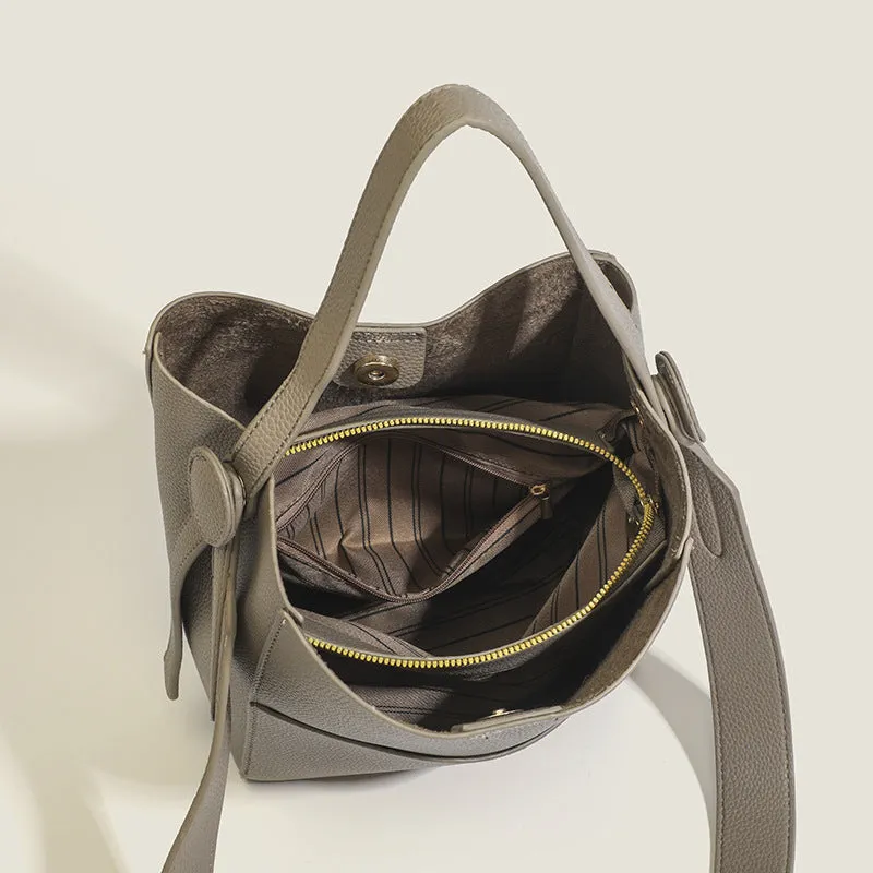 Bucket-style PU messenger bag with sewing line detail, available in black, brown, and elephant gray, on a plain background
