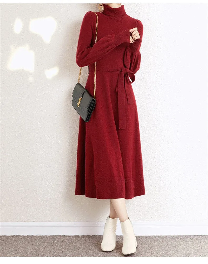 Rose red loose turtleneck knit dress with long sleeves and a flared skirt hem on a hanger.