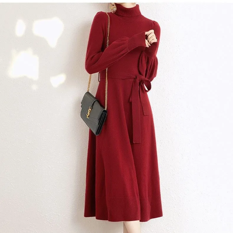 Rose red loose turtleneck knit dress with long sleeves and a flared skirt hem on a hanger.