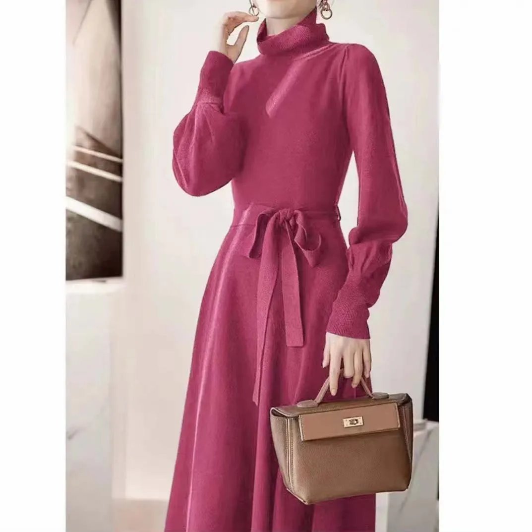 Rose red loose turtleneck knit dress with long sleeves and a flared skirt hem on a hanger.