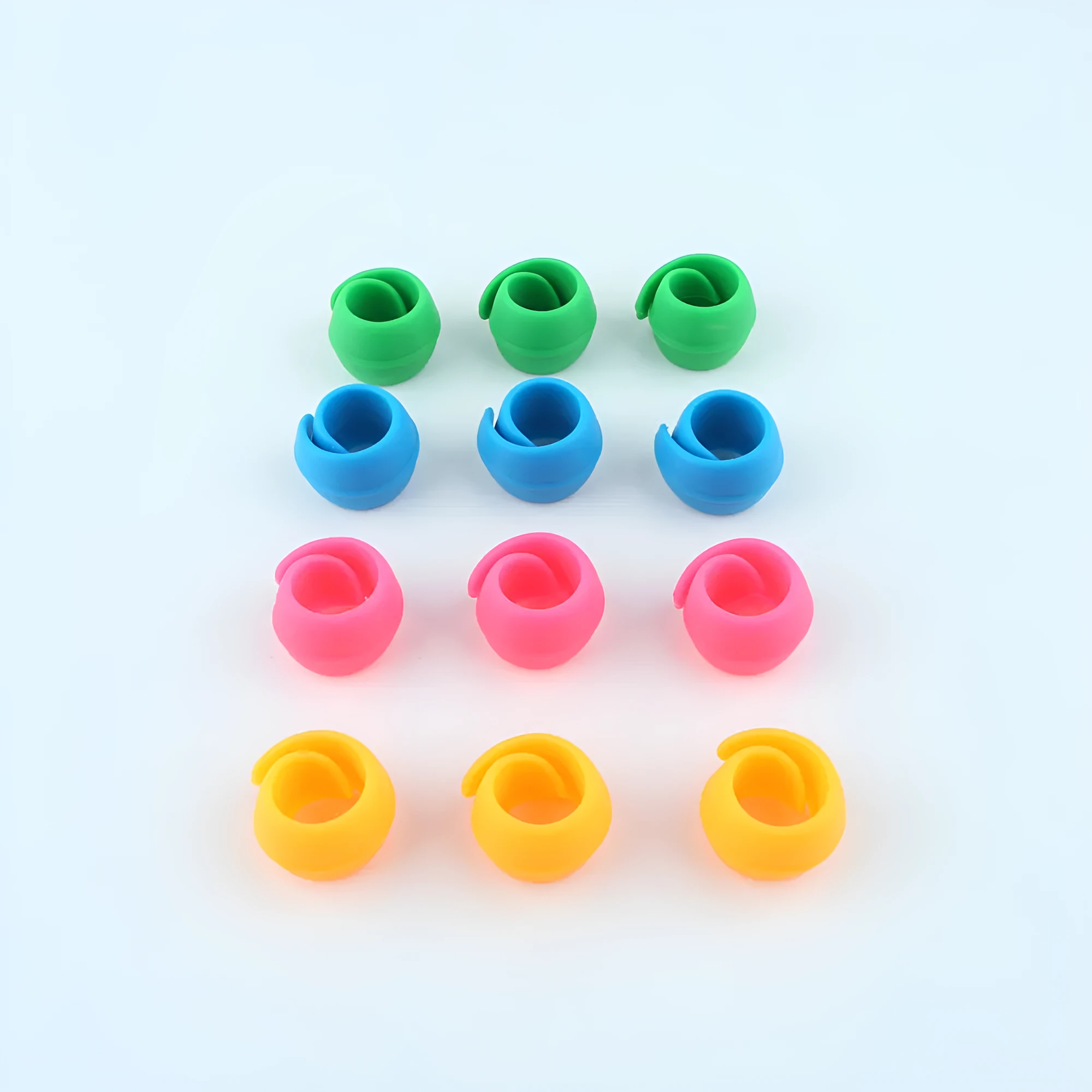14 silicone sewing spool fixed clips in red, blue, orange, and green on a white background
