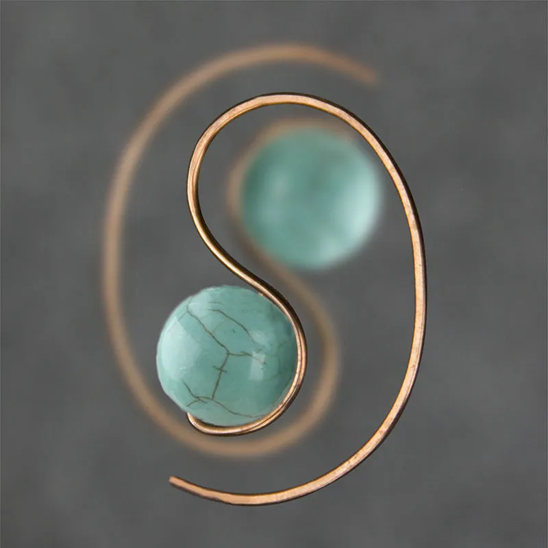 Green turquoise retro style dangle earrings with blue turquoise centrepiece on a white background