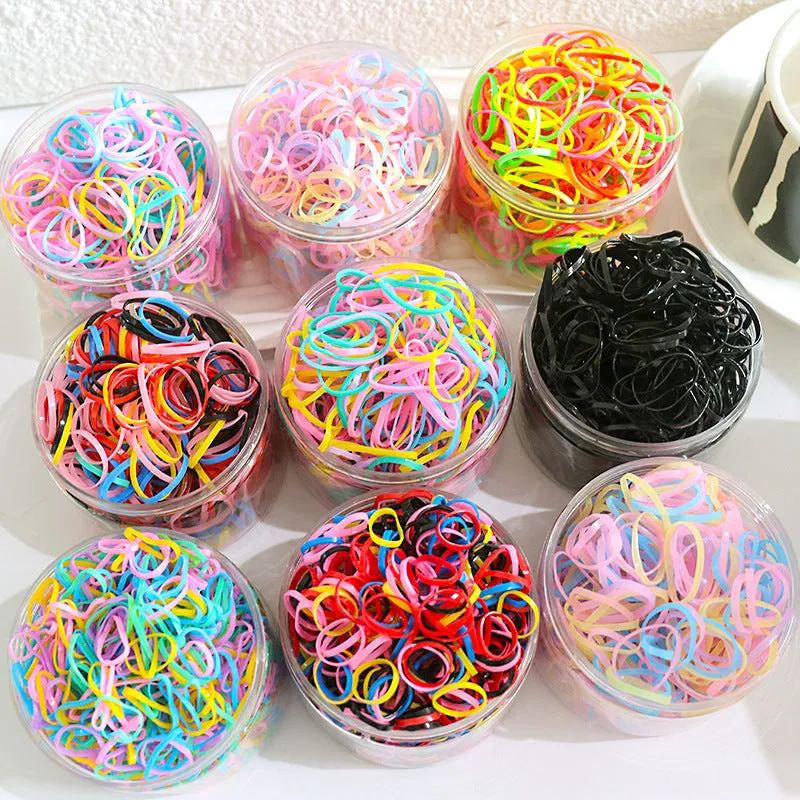 Multi-colour assortment of thin TPU baby hair ties in a re-useable plastic storage container.