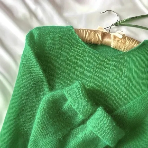 Green crew neck loose fit long sleeve polyester pullover sweater for women on plain background