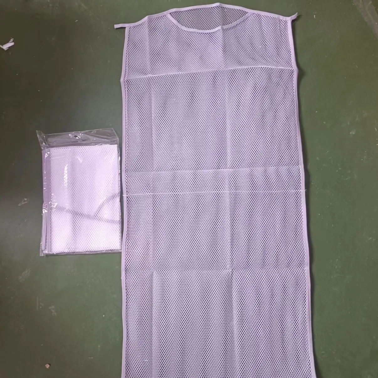 White fabric mesh pillow drying hanger with net pocket on a clothesline outdoors