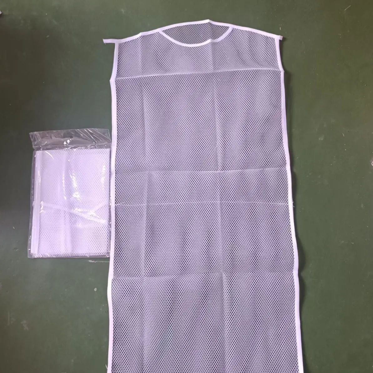 White fabric mesh pillow drying hanger with net pocket on a clothesline outdoors