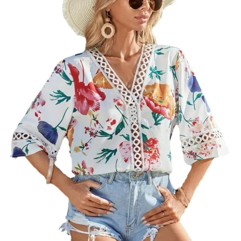 Loose V-neck pullover top with bell sleeves, lace trim, and printed pattern in white