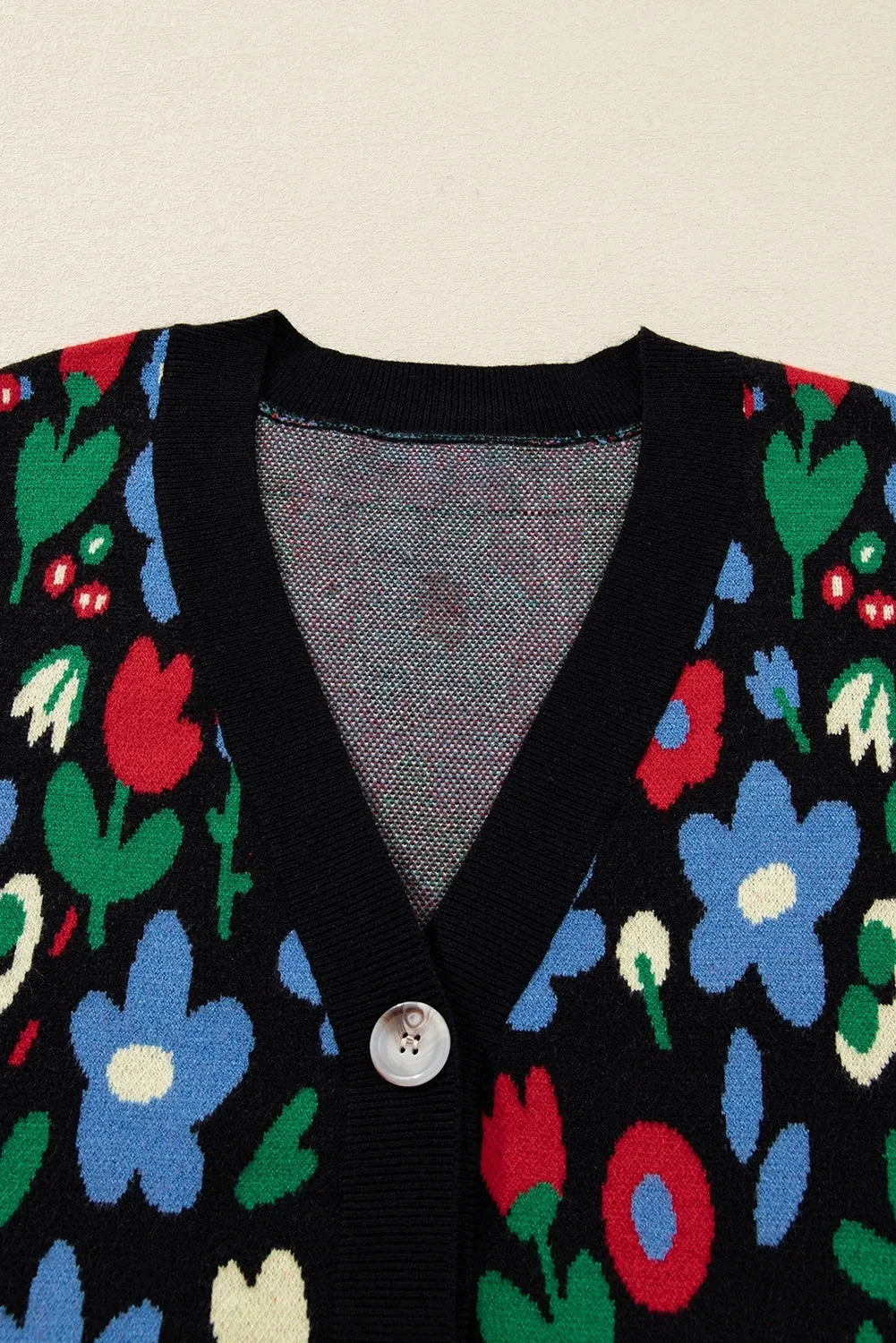 Black floral print V-neck button short cardigan sweater on model, long sleeves, shift silhouette