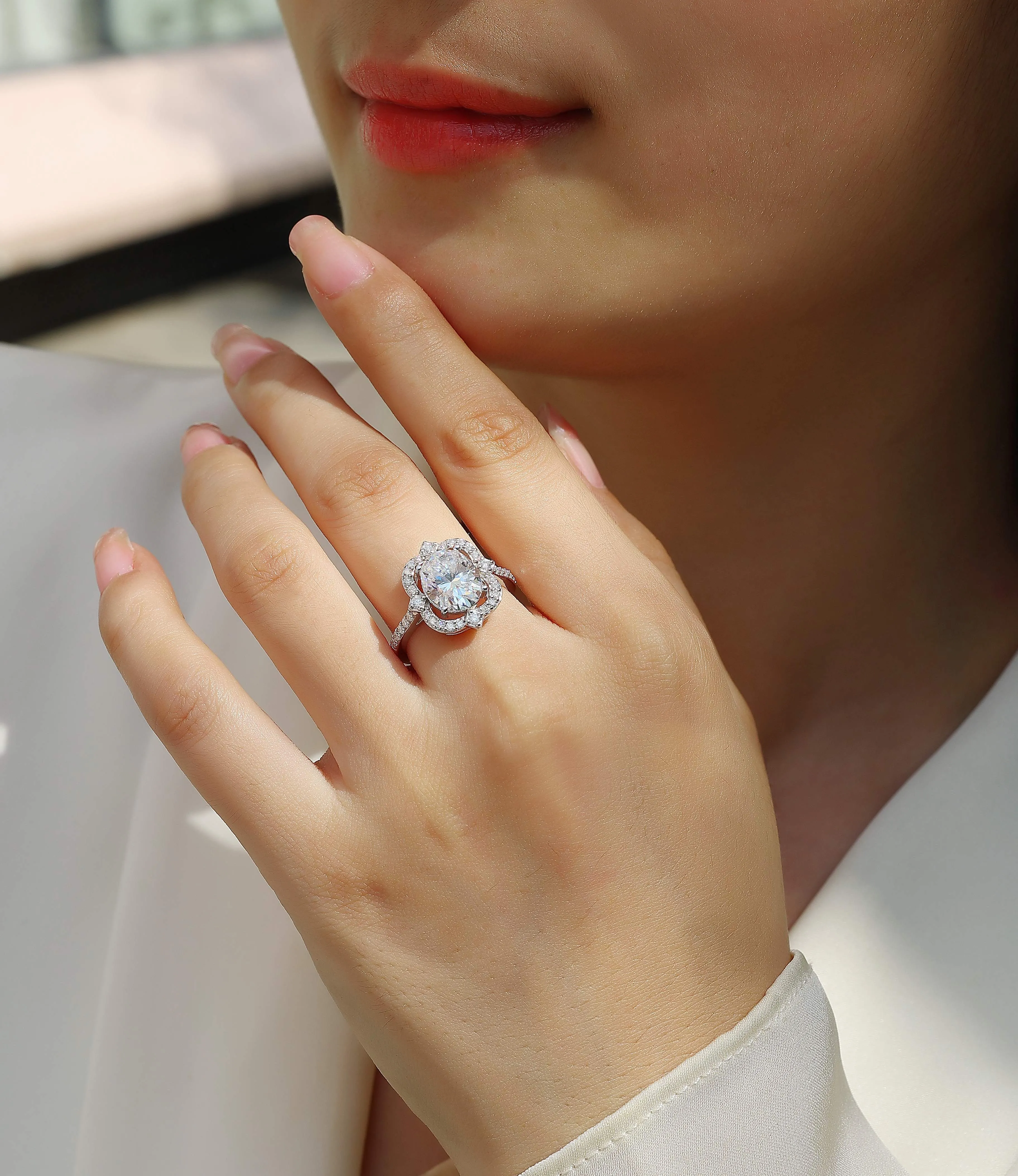 Egg-shaped moissanite ring set with S925 silver and platinum plating on a white surface