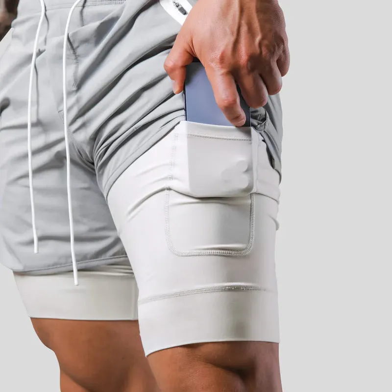 Men's double layer running shorts in light slate green and black, with built-in lining and mid-rise waist for fitness use