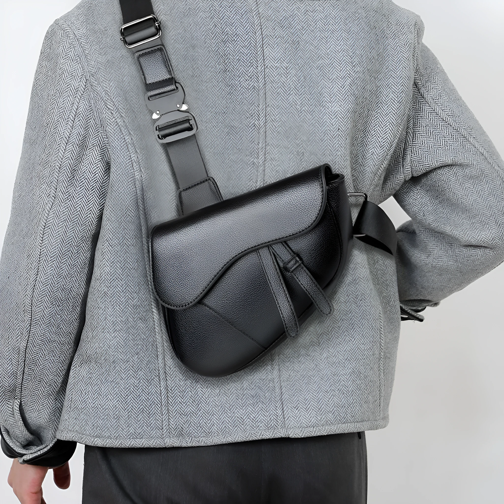 Unisex saddle shoulder crossbody chest bag in black synthetic leather with stitching and splicing details