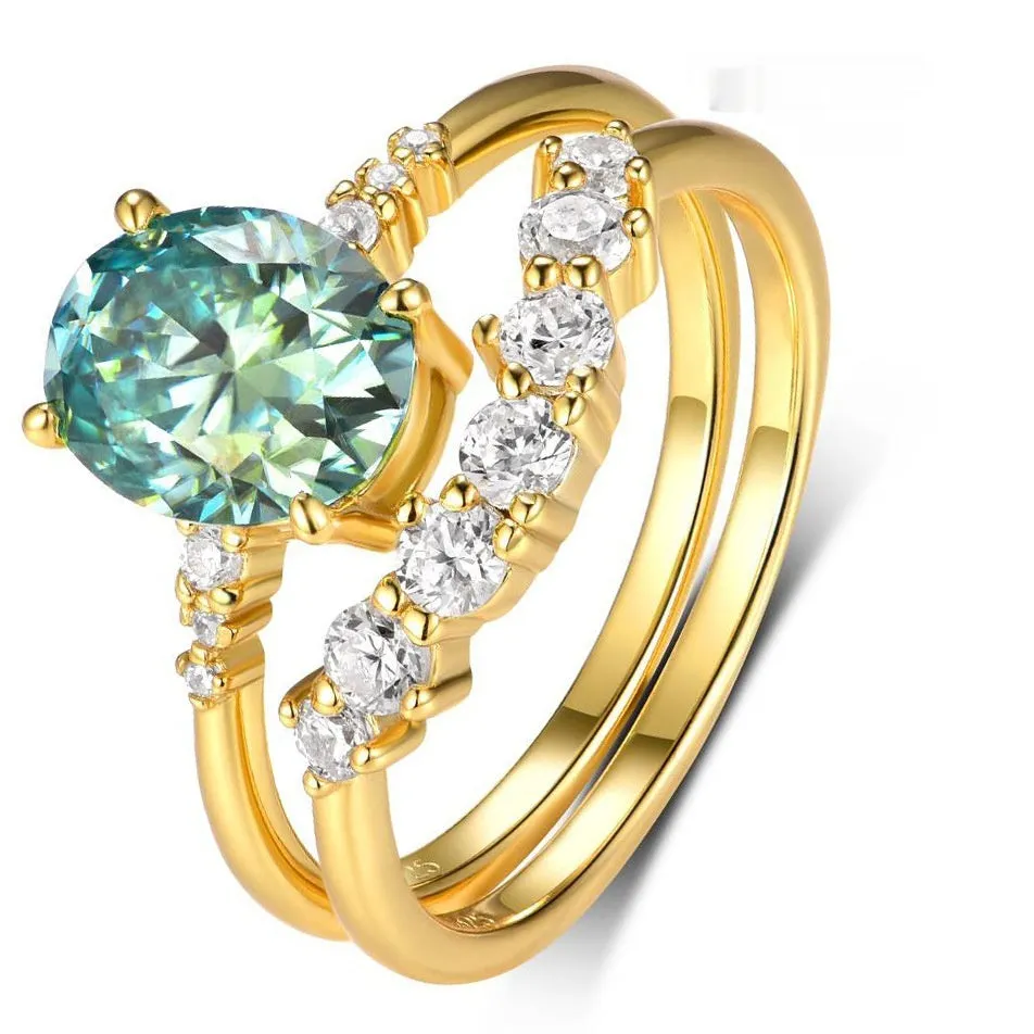 Gold S925 silver ring set with green moissanite stone, crown and geometric design, stacked on finger.