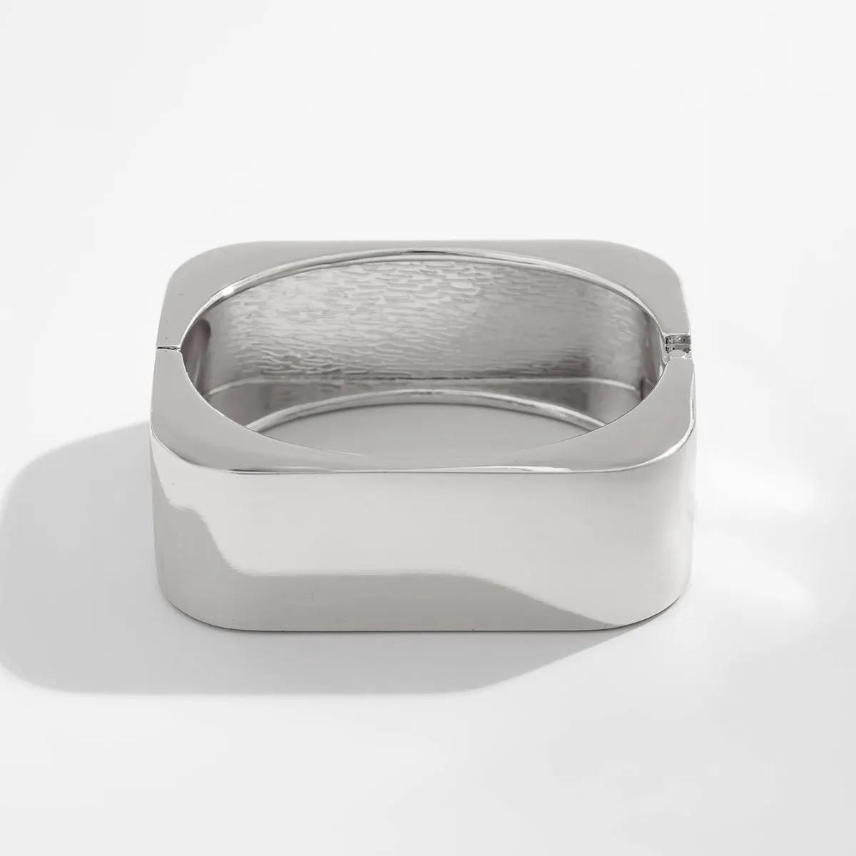 Metal texture glossy spring bracelet with geometric square mirror design in gold colour on white background