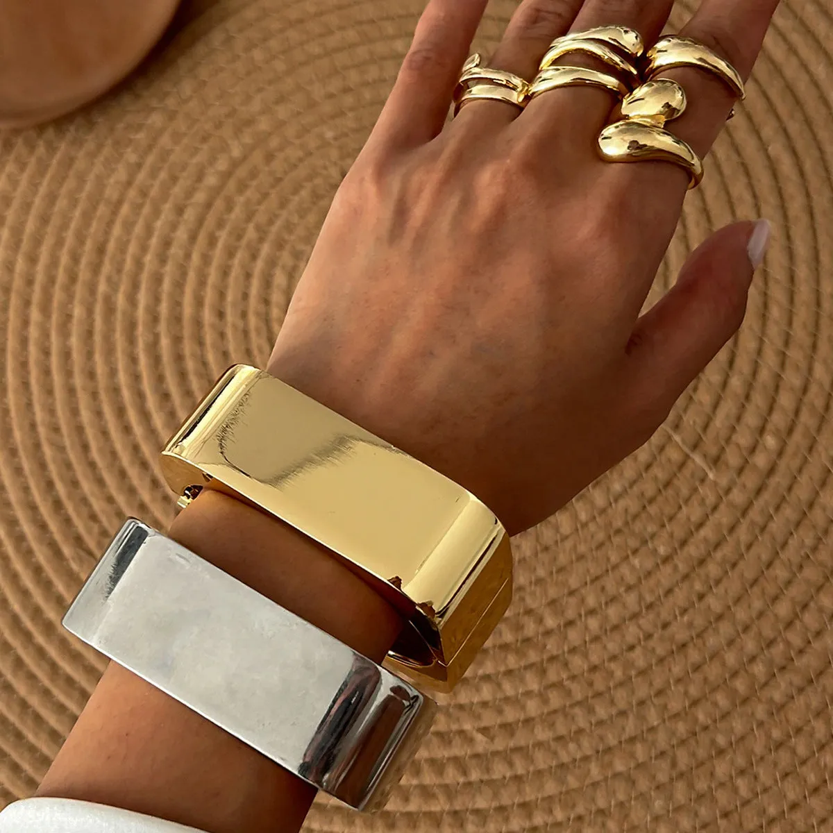 Metal texture glossy spring bracelet with geometric square mirror design in gold colour on white background