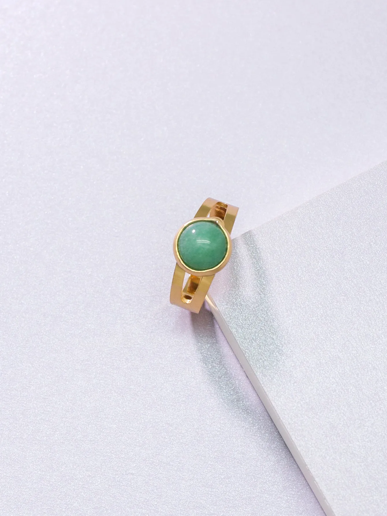 Copper adjustable ring with green natural stone inlay and gold-toned plating on white background