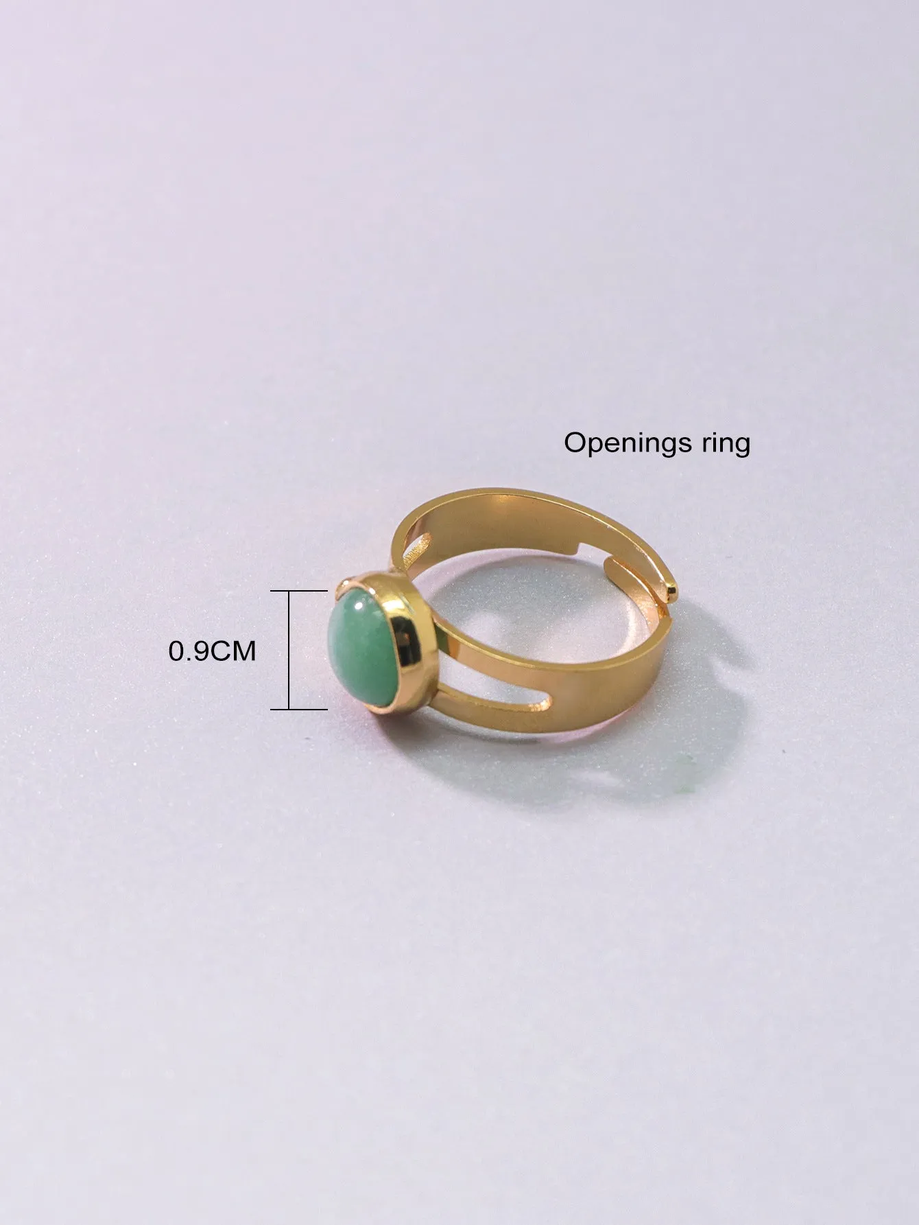 Copper adjustable ring with green natural stone inlay and gold-toned plating on white background