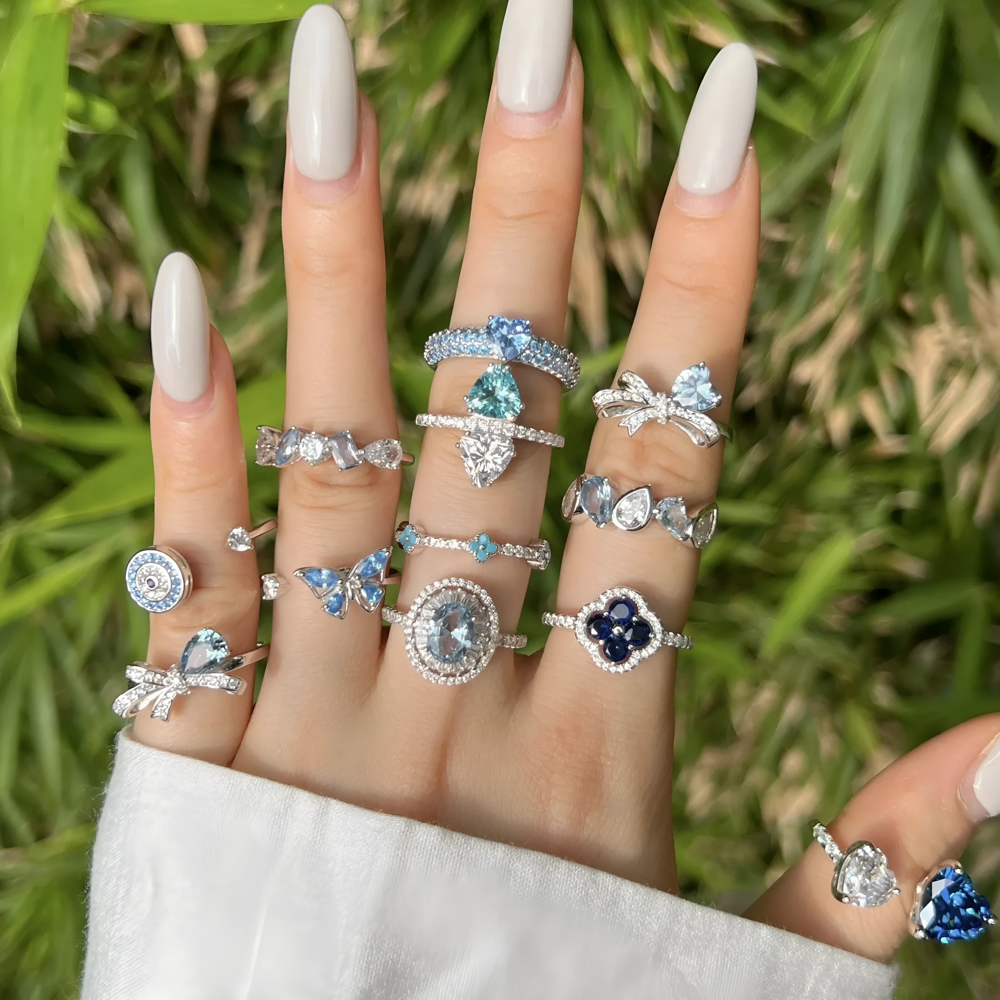 Women's S925 sterling silver ring with sea blue zircon heart or bow shape on plain background