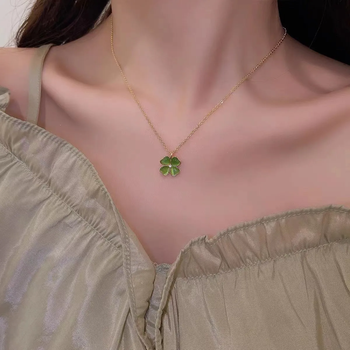 Titanium steel golden clavicle chain with geometric four-leaf flower design on unisex display