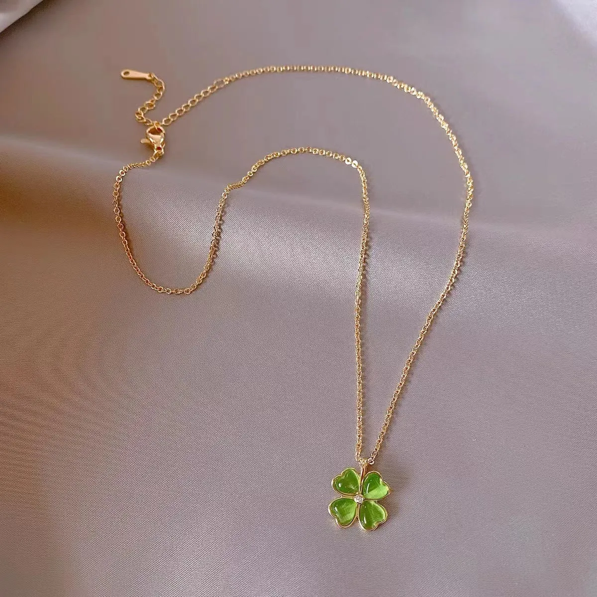Titanium steel golden clavicle chain with geometric four-leaf flower design on unisex display