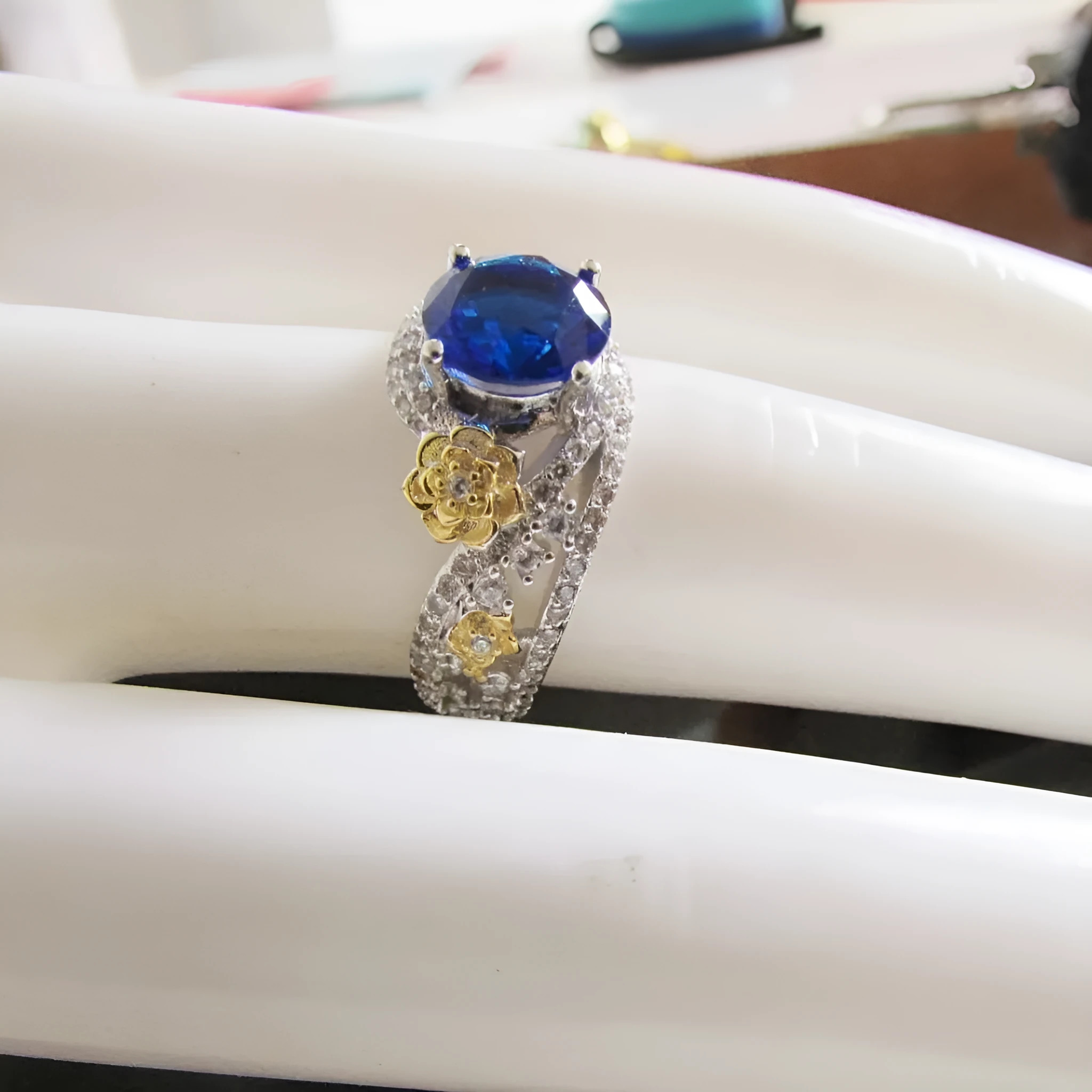 Flower rose two-tone copper ring for women with blue artificial gemstone on a white background